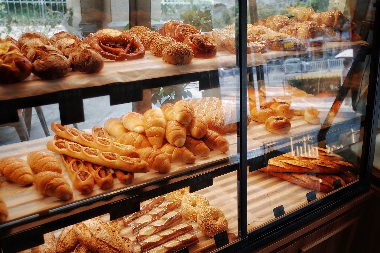 Loaves of bread on display shelves in a small bakery